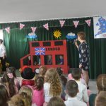 Dzieci i nauczycielka w czasie wystapienia artystycznego na sali.