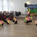 Grupa młodych dziewcząt w czasie występu tancznego na duzej sali.