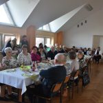 Grupa ludzi siedząca przy zastawionym stole