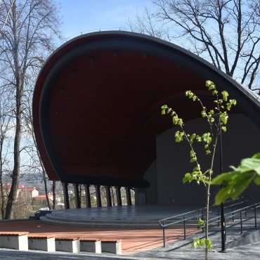 Budynek w kształcie muszli na tle drzew