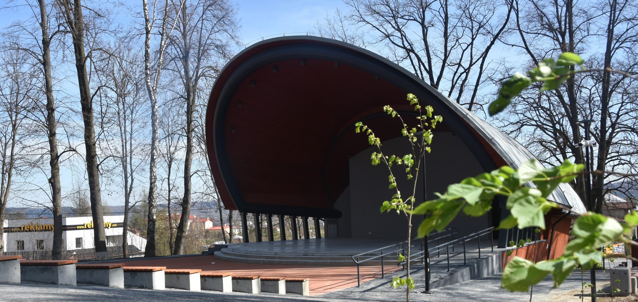 Budynek w kształcie muszli na tle drzew