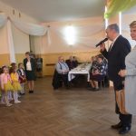 Starszy mężczyzna i kobieta na sali. W tle kobiety i dzieci.