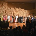 Grupa aktorów i młoda piosenkarka na sali gimastycznej w czasie Misterium Męki Pańskiej.