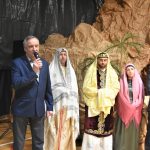 Dwóch mężczyzn ubranych w garnitury oraz aktorzy ubrani w stroje przedstawiajace postacie nowotestamentalne.