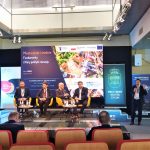 Grupa mężczyzn w garniturach w czasie dabaty na rozległej sali.