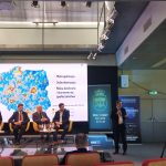 Grupa mężczyzn w garniturach w czasie dabaty na rozległej sali.