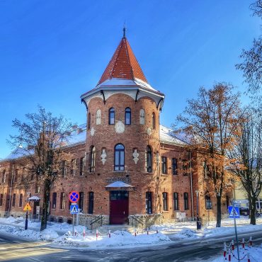 Budynek z cegły przykryty dachówką w zimowej scenerii