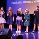 Grupa dziewcząt podczas wystepu muzycznego na sali kinowej.