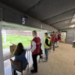 Grupa osób podczas trenigu na strzelnicy.