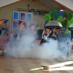 Grupa młodych dziewcząt wykonująca układ taneczny z parasolkami.