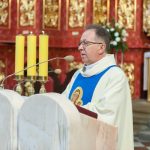 Kapłan przemawiajacy przy mównicy w kościele.