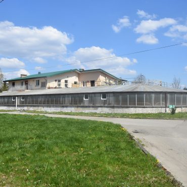 Duży budynek oczyszczalni. W tle niebo i chmury.