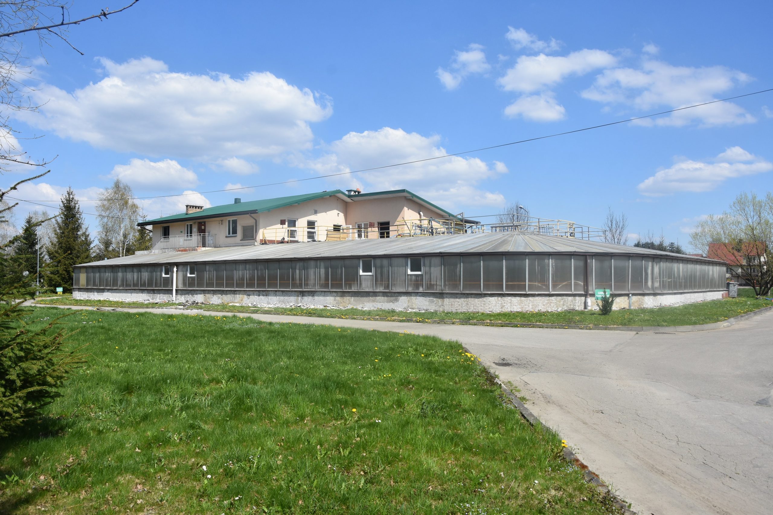 Duży budynek oczyszczalni. W tle niebo i chmury.