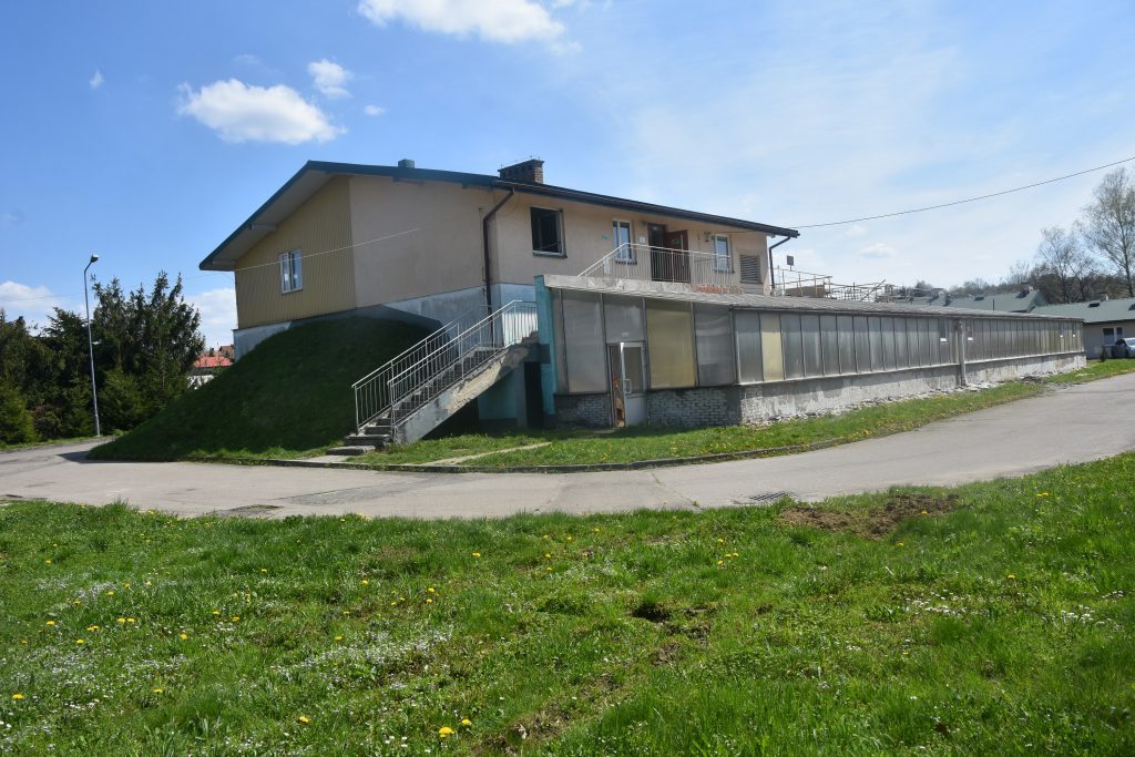 Duży budynek oczyszczalni. W tle niebo i chmury.