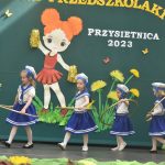 Czwórka dziewczynek w wieku przedszkolnym wykonująca układ taneczny.