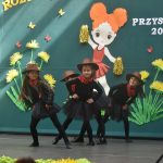 Czwórka dziewczynek w wieku przedszkolnym wykonująca układ taneczny.