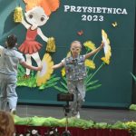 Dwie dziewczynki w wieku przedszkolnym wykonują układ taneczny z wachlarzami.