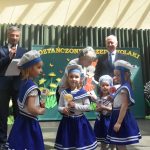 Czwórka dziewczynek w wieku przedszkolnym oraz dwóch mężczyn i starsza kobieta pozujaca do zdjecia.