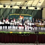 Grupa dorosłych i dzieci z dyplomami pozuje do pamiątkowego zdjęcia.