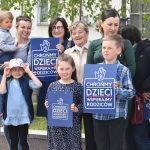 Grupa osób głównie matek z dziećmi pozujących do zdjęcia.