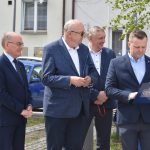 Grupa czterech mężczyzn w garniturach stojąca na rynku.