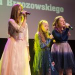 Grupa dziewcząt podczas wystepu muzycznego na sali kinowej.