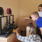 Grupa dzieci obserwuje prace maszyny drukarskiej