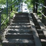 Zniszczone schody z podjazdem dla inwalidów i poręczą