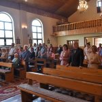 Grupa ludzi stoi i modli się.