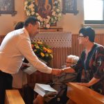 Mężczyzna podający dłoń kobiecie i wręcza list gratulacyjny