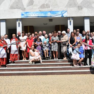 Grupa ludzi stojąca na schodach pozuje do zdjęcia