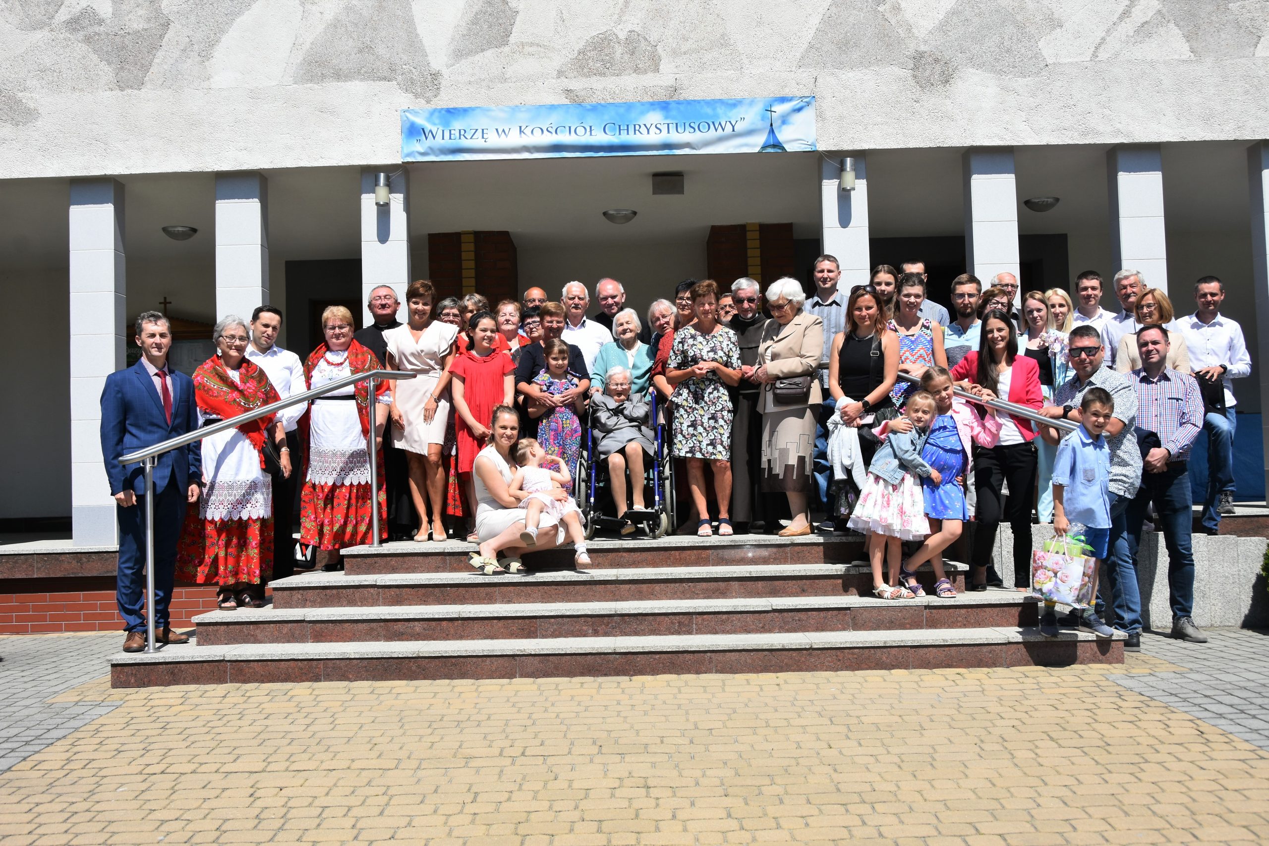 Grupa ludzi stojąca na schodach pozuje do zdjęcia