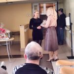 Młoda kobieta przekazuje podziekwoanie drugiej kobiecie.