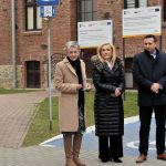 Grupa trzech osób, dwie kobiety i mężczyzna stoją na zewnątrz i przemawiają.