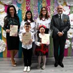 Trzy kobiety i mężczyzna wraz z dwójką dzieci, chłopcem i dziewczynką stoją na ściance i pozują do wspólnego zdjęcia.